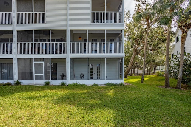 back of property with a balcony and a yard