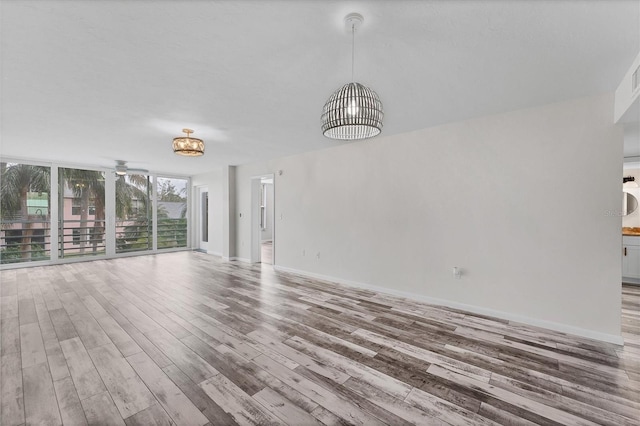 unfurnished living room with hardwood / wood-style flooring and ceiling fan