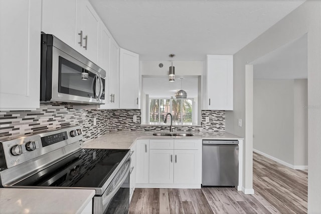 kitchen featuring stainless steel appliances, white cabinetry, sink, and light hardwood / wood-style flooring