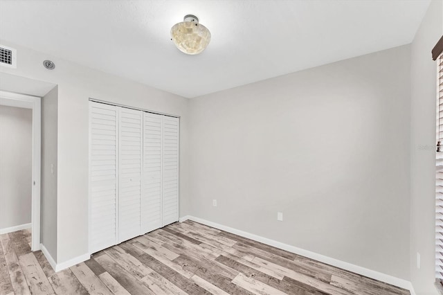 unfurnished bedroom featuring a closet and light hardwood / wood-style floors