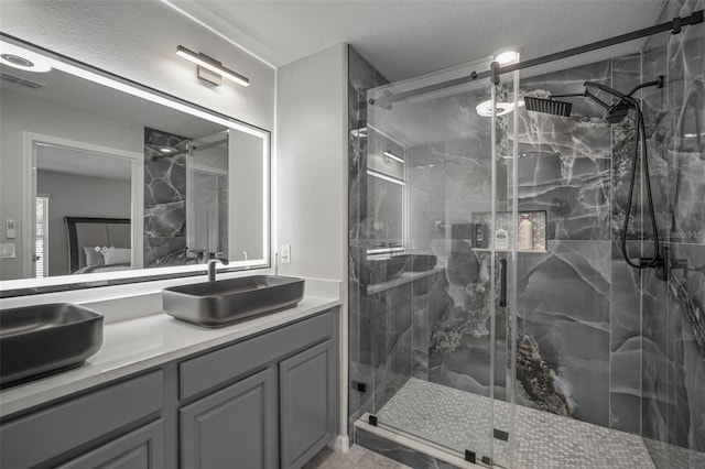 bathroom with vanity, tile patterned floors, an enclosed shower, and a textured ceiling