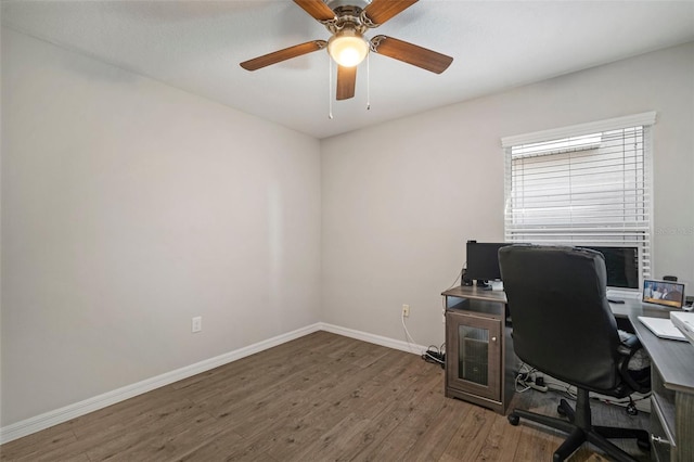 home office with dark wood-type flooring and ceiling fan