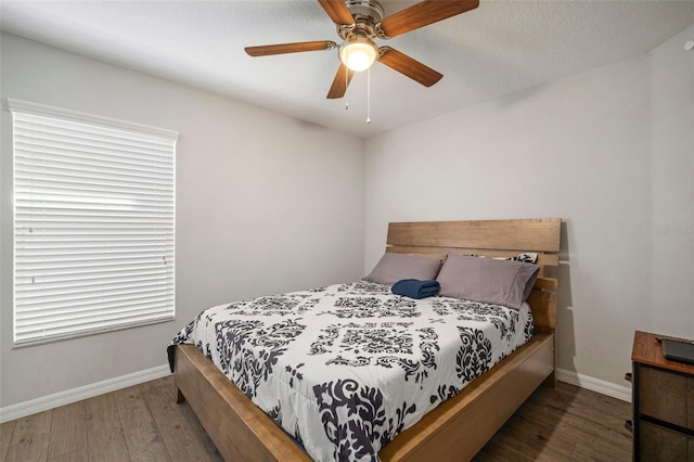 bedroom featuring dark hardwood / wood-style flooring, a textured ceiling, and ceiling fan