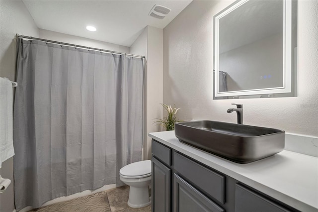 bathroom featuring toilet, vanity, and tile patterned floors