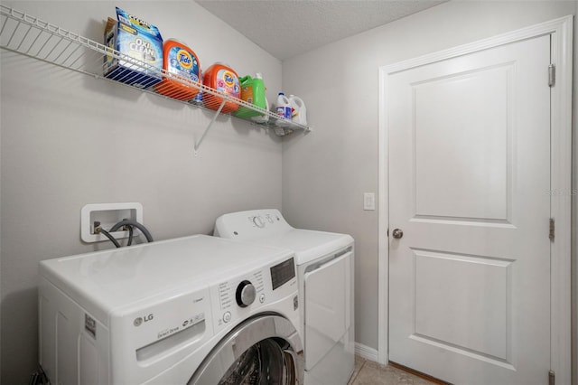 laundry area featuring a textured ceiling and washer and clothes dryer