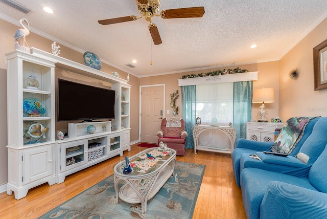 living room featuring ceiling fan, wood-type flooring, crown molding, and a textured ceiling