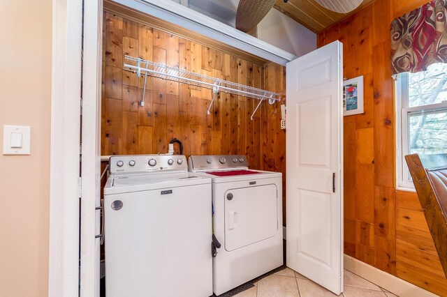 10036 63rd Ave N Unit 23, Saint Petersburg, FL 33708 - laundry area featuring washing machine and clothes dryer, light tile patterned floors, and wooden walls