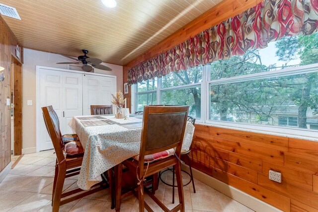 tiled dining room with ceiling fan and wooden ceiling