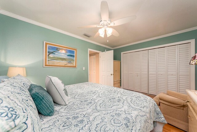 bedroom with wood-type flooring, ceiling fan, a closet, and ornamental molding