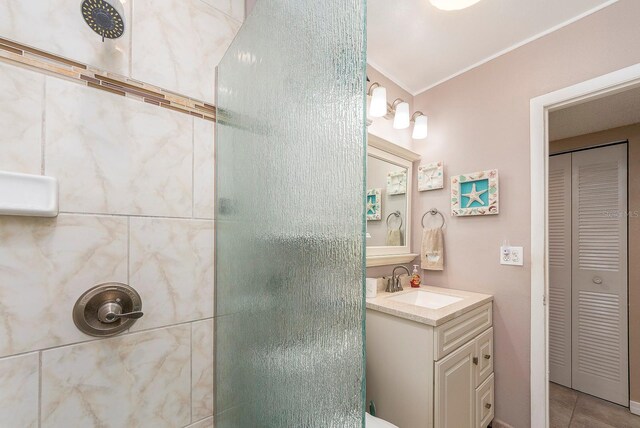 10036 63rd Ave N Unit 23, Saint Petersburg, FL 33708 - bathroom with a closet, a tile shower, vanity, crown molding, and tile patterned flooring