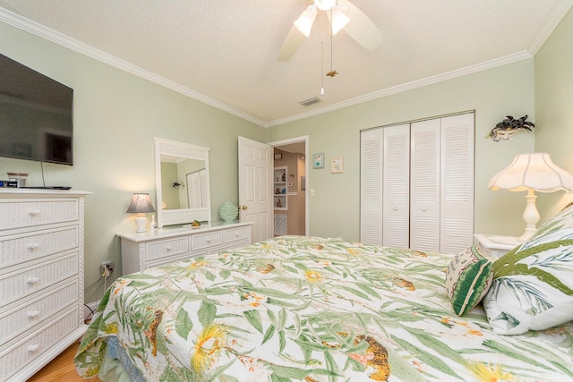 bedroom featuring ornamental molding, a textured ceiling, ceiling fan, and a closet