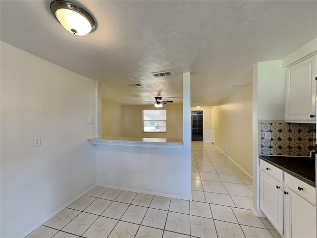 kitchen featuring ceiling fan, white cabinetry, light tile patterned floors, and a textured ceiling