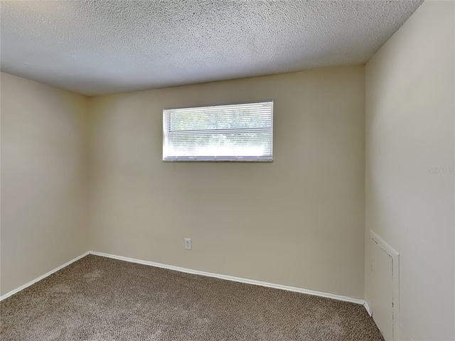 spare room featuring a textured ceiling and carpet