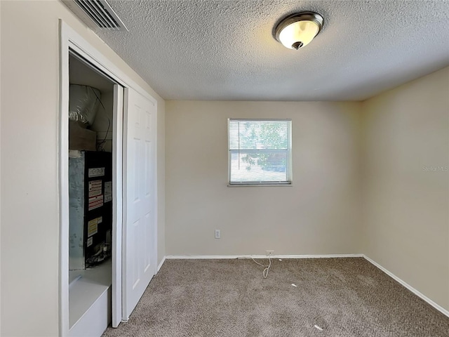 unfurnished bedroom featuring a closet, a textured ceiling, and light carpet