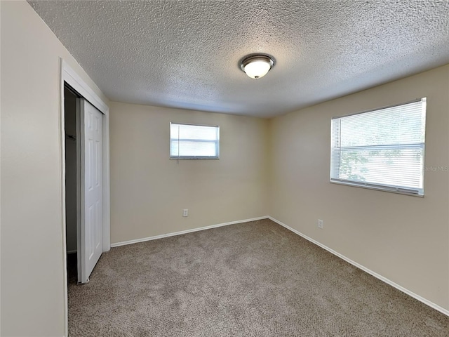 unfurnished bedroom featuring a closet, a textured ceiling, and carpet flooring