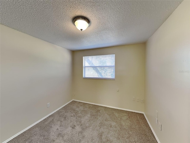 carpeted empty room featuring a textured ceiling