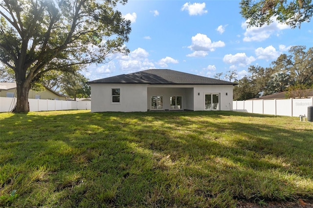 rear view of property featuring a lawn