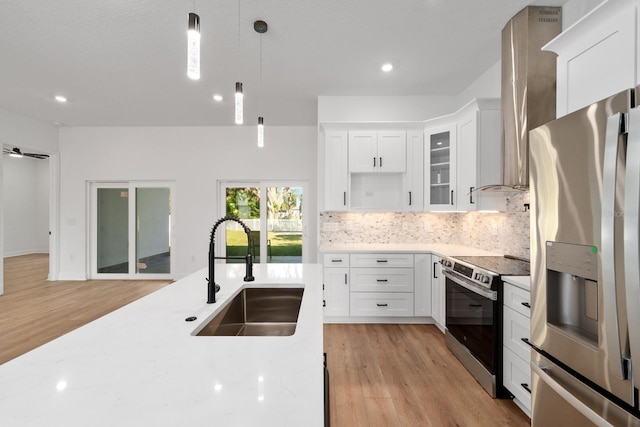 kitchen featuring sink, stainless steel appliances, decorative light fixtures, and white cabinets