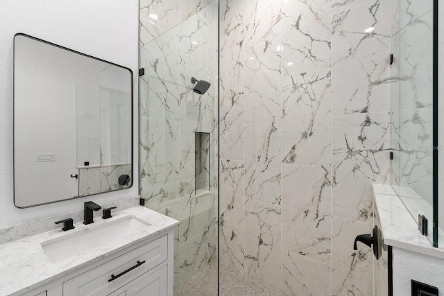 bathroom featuring a tile shower and vanity