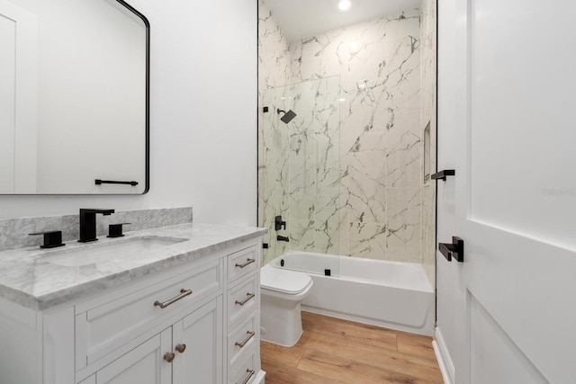 full bathroom with toilet, vanity, hardwood / wood-style flooring, and washtub / shower combination