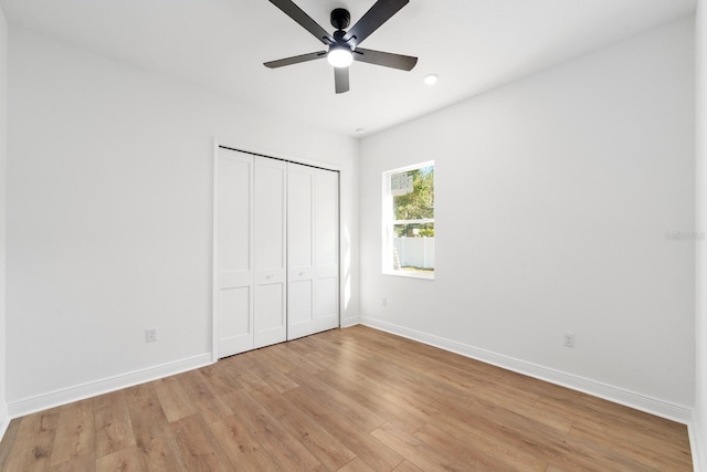 unfurnished bedroom featuring ceiling fan, light hardwood / wood-style floors, and a closet