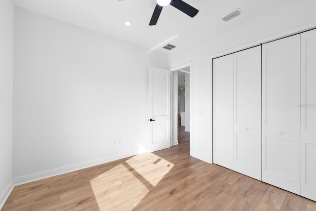 unfurnished bedroom featuring ceiling fan, light hardwood / wood-style flooring, and a closet