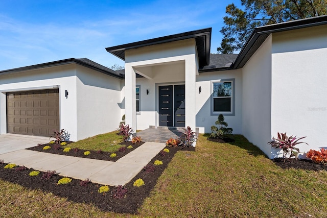 view of exterior entry featuring a yard and a garage