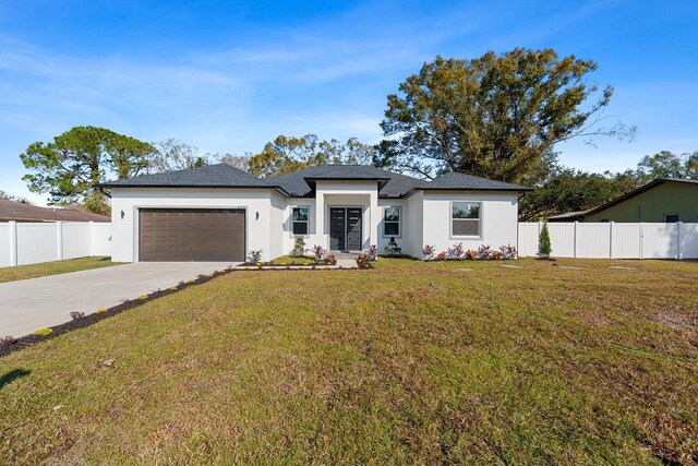 view of front of property with a garage and a front lawn