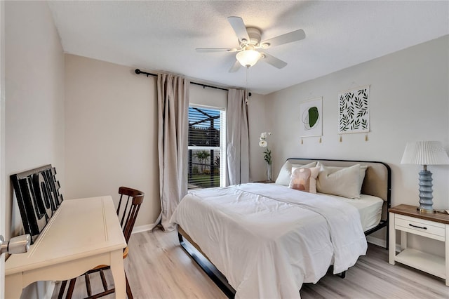 bedroom with light hardwood / wood-style floors, a textured ceiling, and ceiling fan