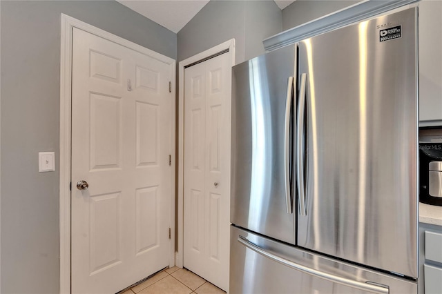 kitchen featuring light tile patterned floors and stainless steel fridge