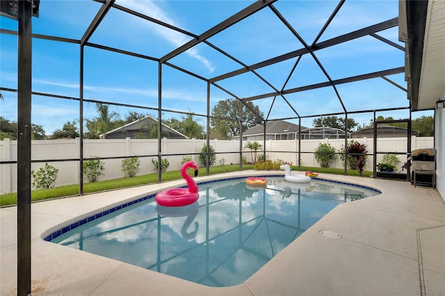 view of pool with glass enclosure and a patio area