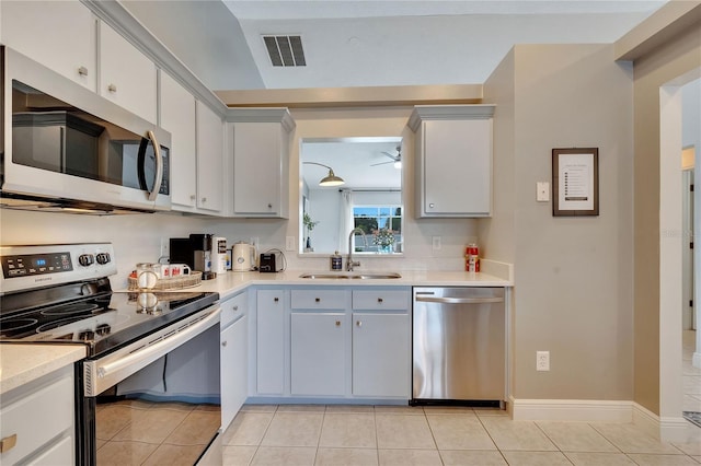 kitchen with stainless steel appliances, light tile patterned floors, and sink