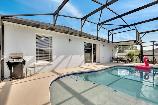 view of pool with area for grilling, glass enclosure, and a patio area