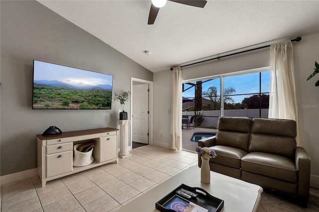 living room featuring a textured ceiling, light tile patterned floors, ceiling fan, and vaulted ceiling