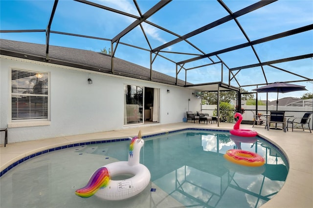 view of pool featuring glass enclosure and a patio area