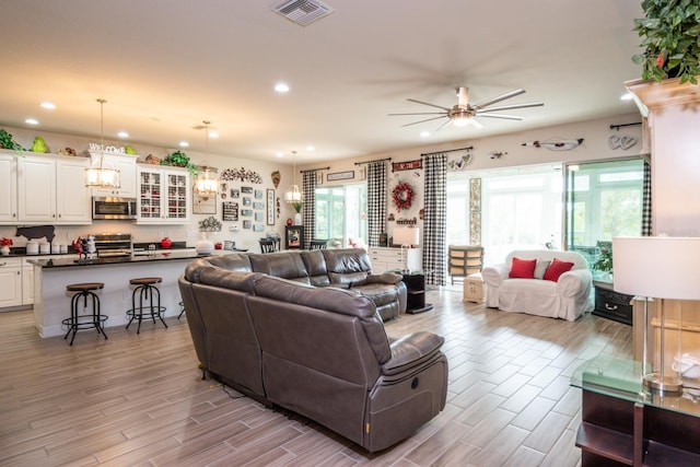 living room with light hardwood / wood-style flooring and ceiling fan