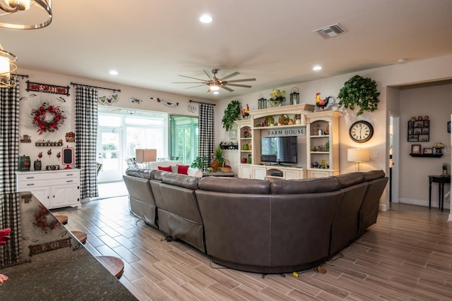 living room with light hardwood / wood-style floors and ceiling fan