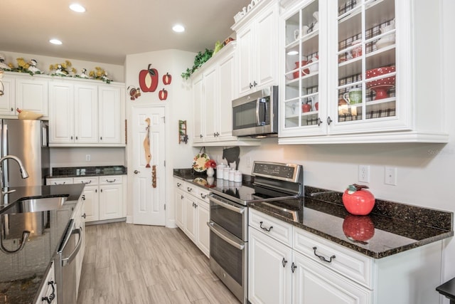 kitchen featuring white cabinets, sink, light hardwood / wood-style floors, and stainless steel appliances