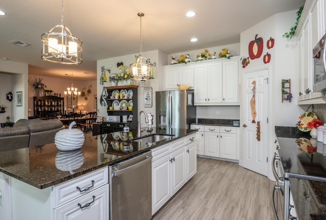 kitchen featuring dark stone counters, hanging light fixtures, sink, white cabinetry, and appliances with stainless steel finishes