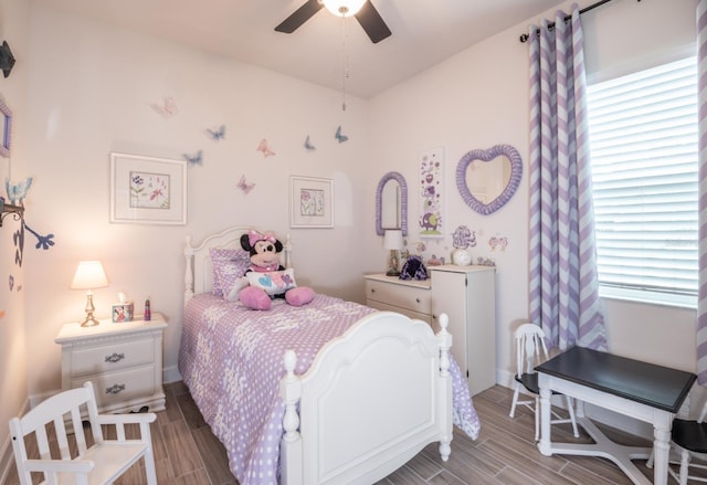 bedroom with multiple windows, wood-type flooring, and ceiling fan