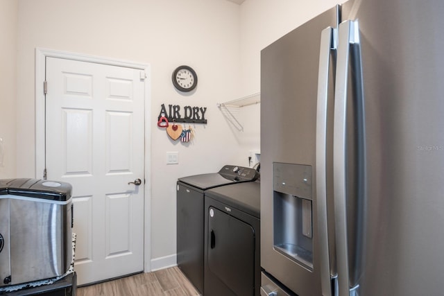 clothes washing area with light hardwood / wood-style floors and independent washer and dryer