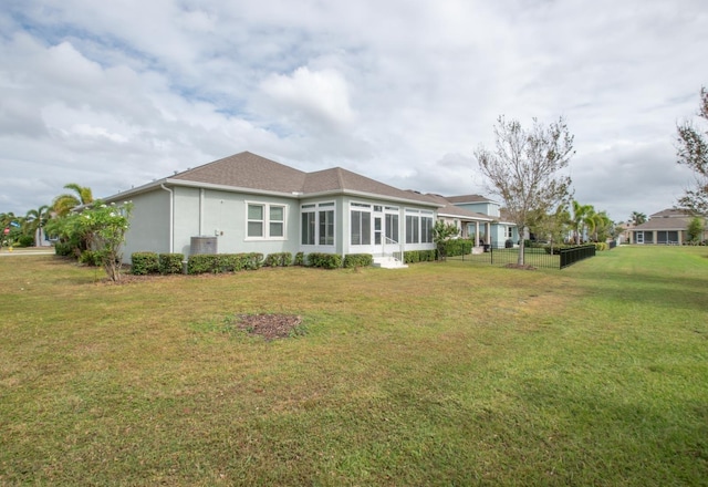 back of house featuring a sunroom and a yard