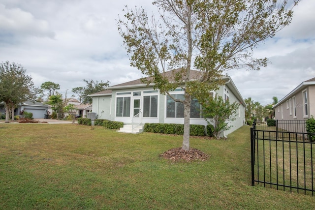 view of home's exterior featuring a garage, a yard, and a sunroom