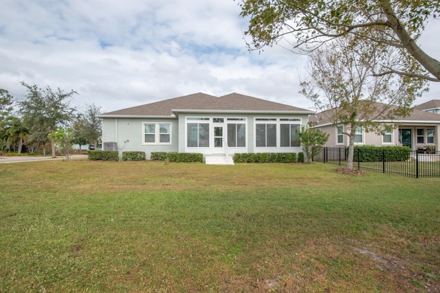 view of front of home with a sunroom and a front lawn