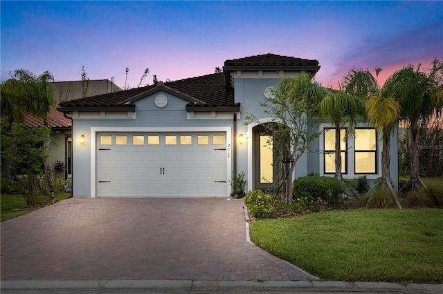 mediterranean / spanish-style home with a yard and a garage