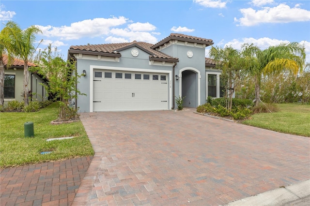 mediterranean / spanish-style house featuring a garage and a front yard