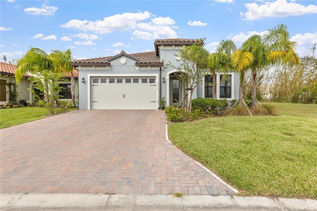 mediterranean / spanish house featuring a garage and a front lawn