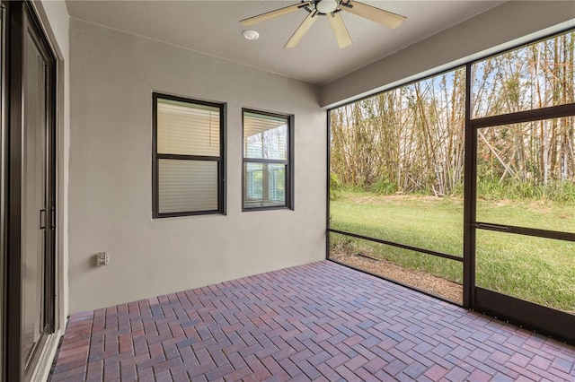 unfurnished sunroom featuring ceiling fan