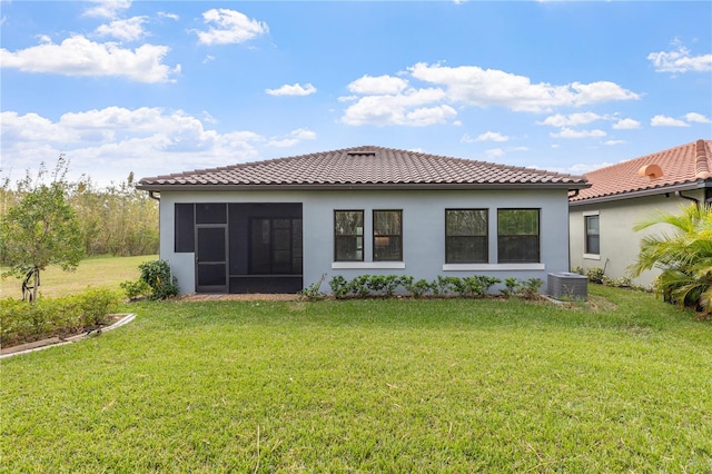 back of property featuring a lawn, a sunroom, and central AC unit