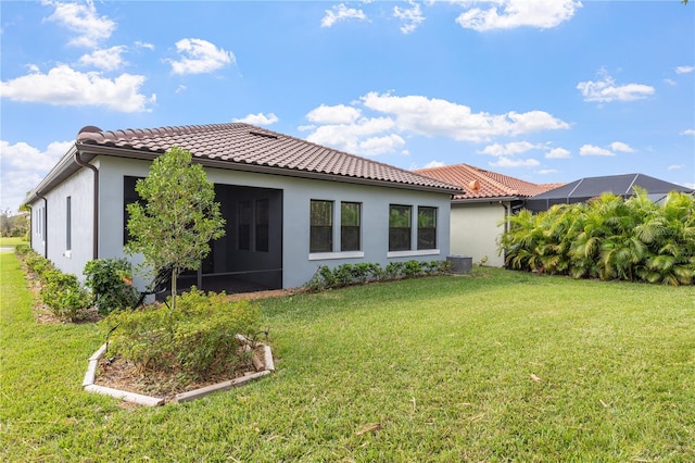 rear view of property with a lawn and central air condition unit